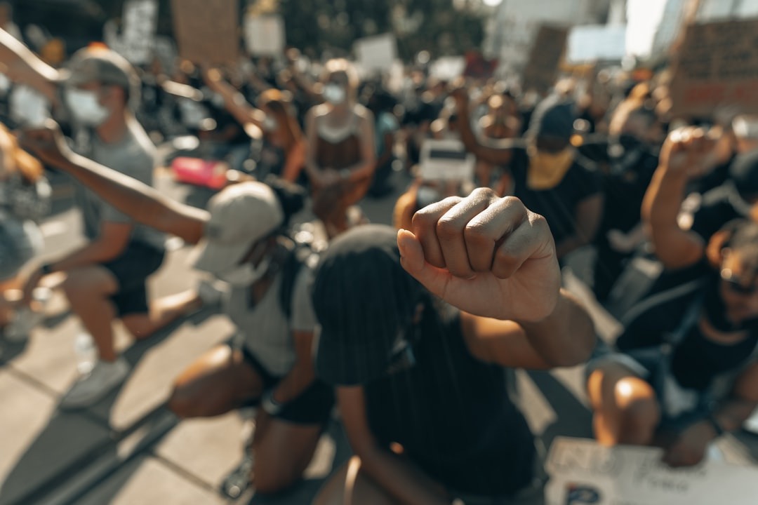 A clenched fist is raised in protest by a group.